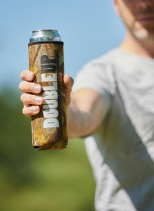 Hand holding a camo. color double can cooler